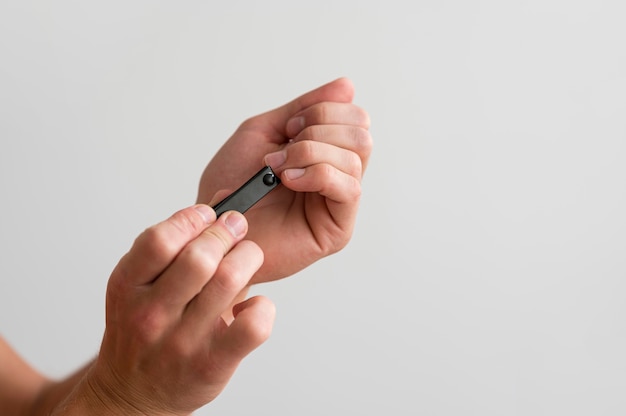 Zijaanzicht van de mens die voor zijn vingernagels zorgt