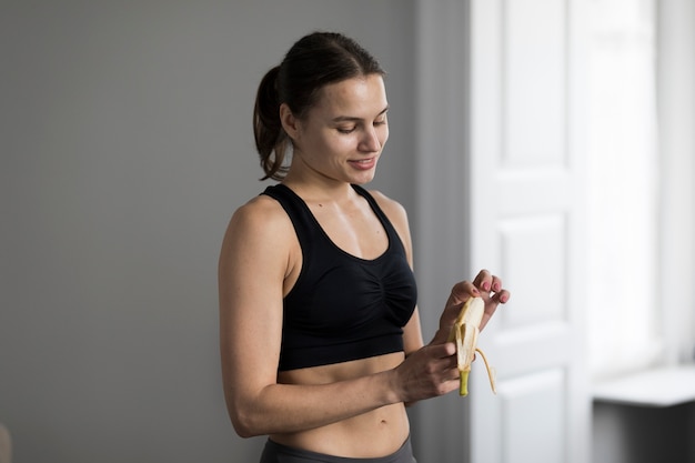 Gratis foto zijaanzicht van de sportieve banaan van de vrouwenschil