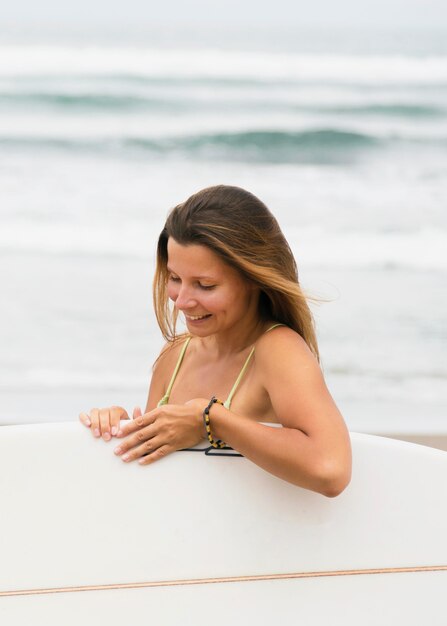 Zijaanzicht van de surfplank van de vrouwenholding bij het strand