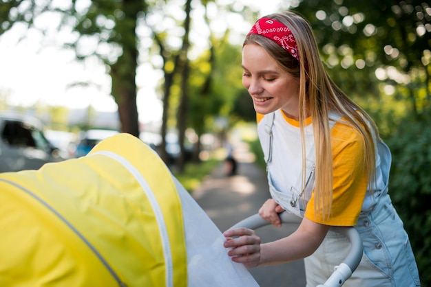 Zijaanzicht van de vrouw buiten met wandelwagen