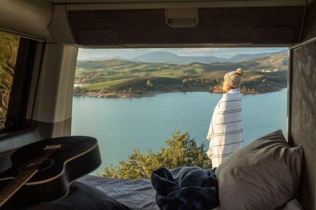 Zijaanzicht van de vrouw die de natuur bewondert tijdens een roadtrip