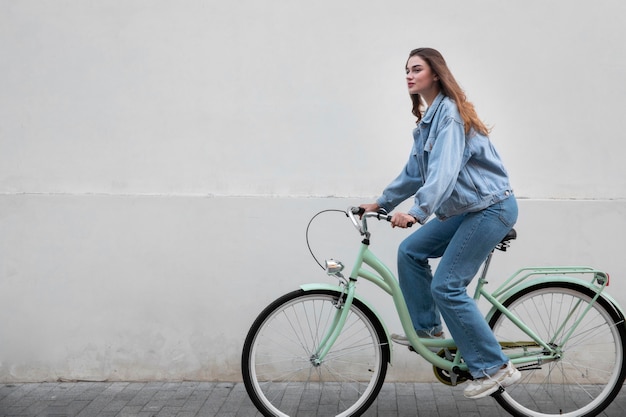 Zijaanzicht van de vrouw die haar fiets berijdt