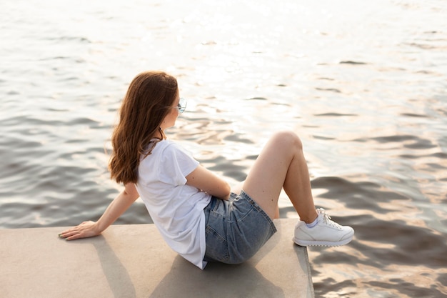 Zijaanzicht van de vrouw die het uitzicht op het meer bewondert