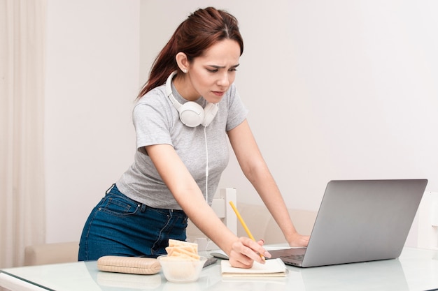 Zijaanzicht van de vrouw die op laptop werkt