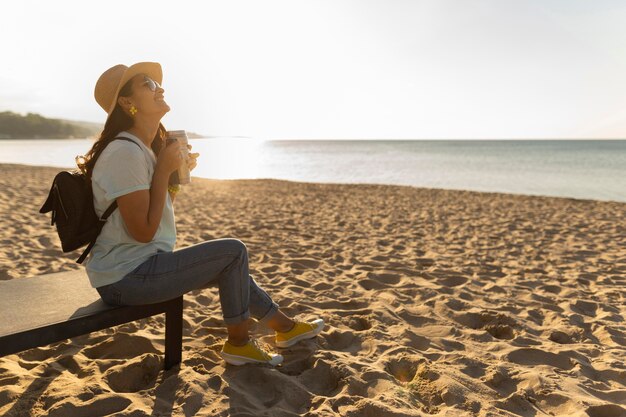 Zijaanzicht van de vrouw genieten van het uitzicht op het strand