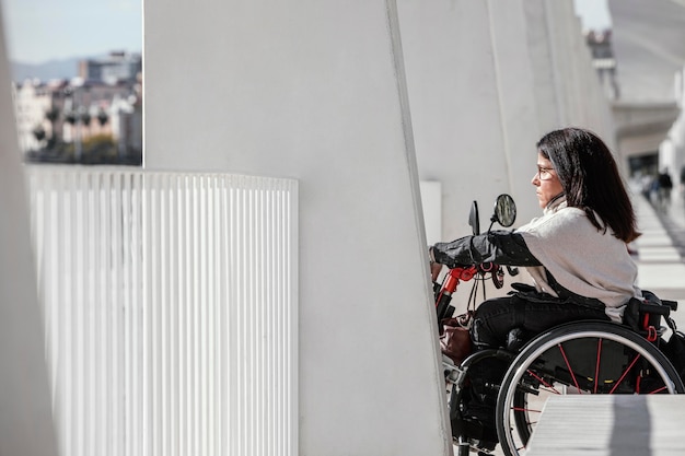Zijaanzicht van de vrouw in een rolstoel in de stad