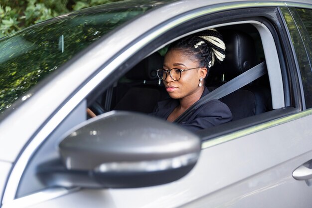 Zijaanzicht van de vrouw op de bestuurdersstoel van haar auto