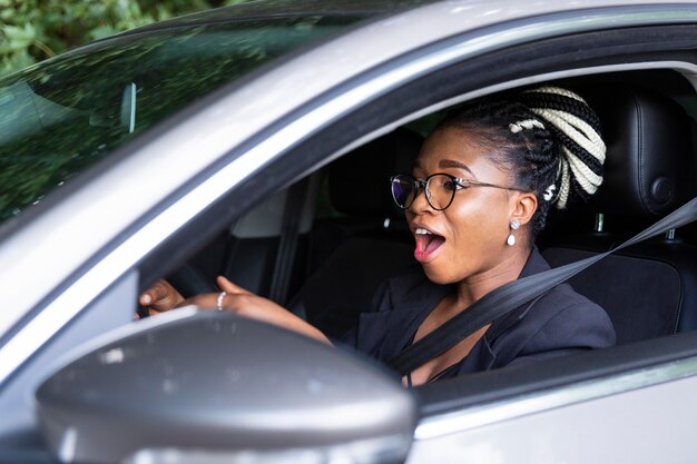 Zijaanzicht van de vrouw opgewonden om haar persoonlijke auto te rijden