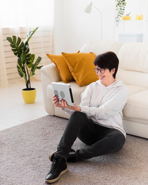 Zijaanzicht van de vrouw thuis met tablet