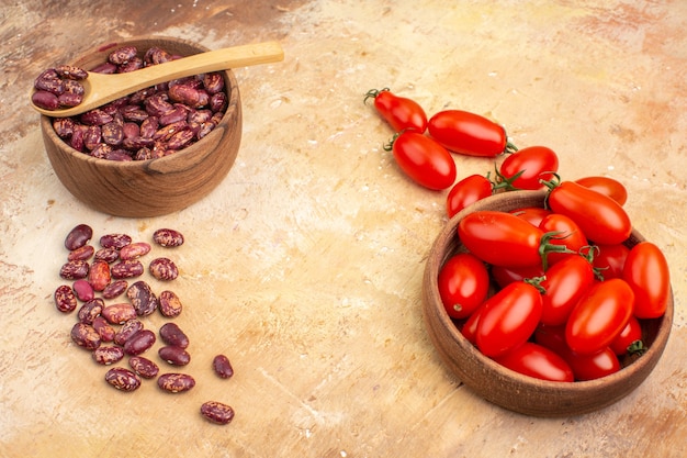 Zijaanzicht van dinerachtergrond met bonen binnen en buiten bruine pot met lepel en tomaten op gemengde kleurenachtergrond