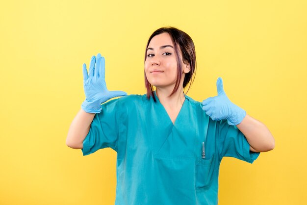 Zijaanzicht van een arts heeft het over het belang van het dragen van medische handschoenen