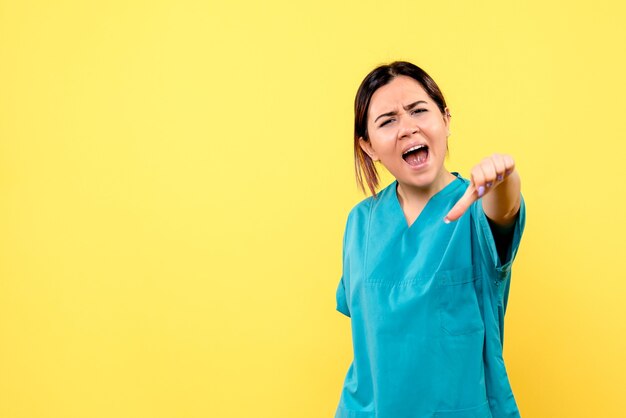 Zijaanzicht van een arts in het medische uniform heeft het over het gedrag van de patiënten