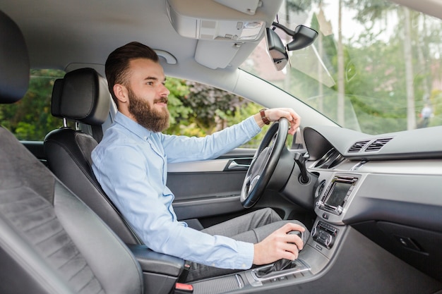 Zijaanzicht van een jonge man rijdende auto