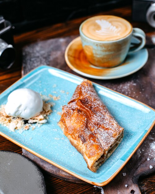 Zijaanzicht van een kopje koffie latte geserveerd met apfelstrudel met ijs