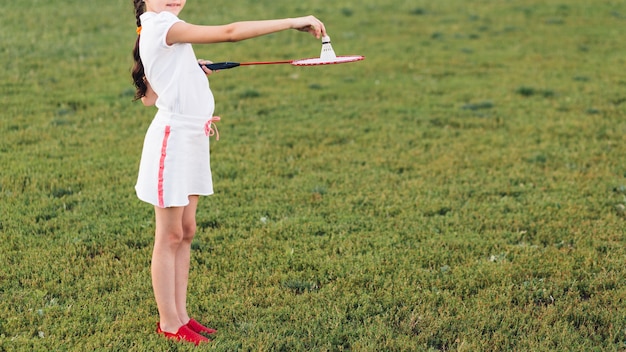 Zijaanzicht van een meisje die met badminton in het park spelen