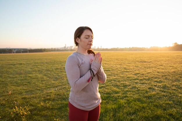 Zijaanzicht van een vrouw die buiten yoga doet