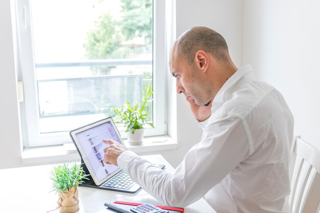 Zijaanzicht van een zakenman die aan laptop werkt