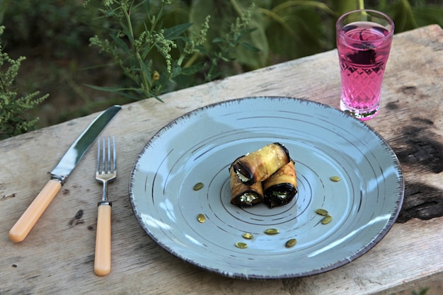 Zijaanzicht van gebraden auberginebroodje met roomkaasknoflook en noten op plaat openlucht