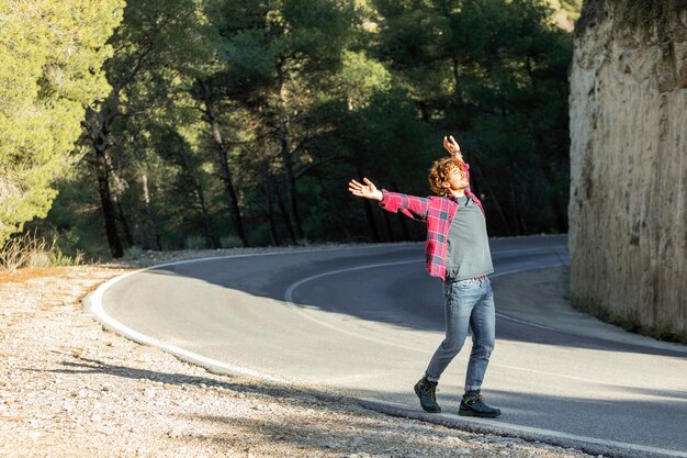 Zijaanzicht van gelukkig man genieten van de natuur tijdens een road trip