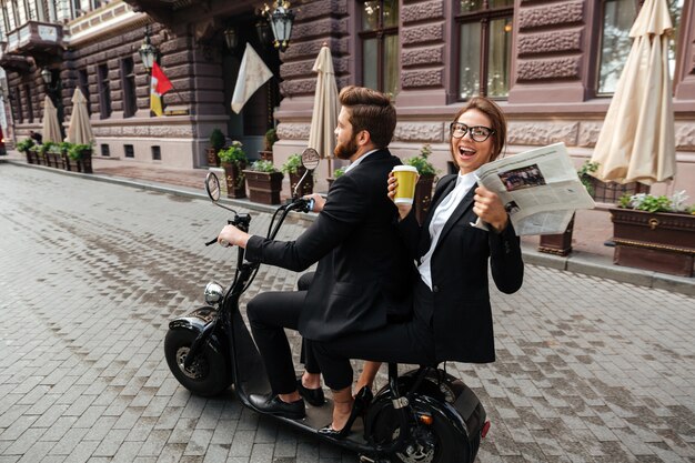 Zijaanzicht van gelukkige stijlvolle paar rijdt op moderne motor