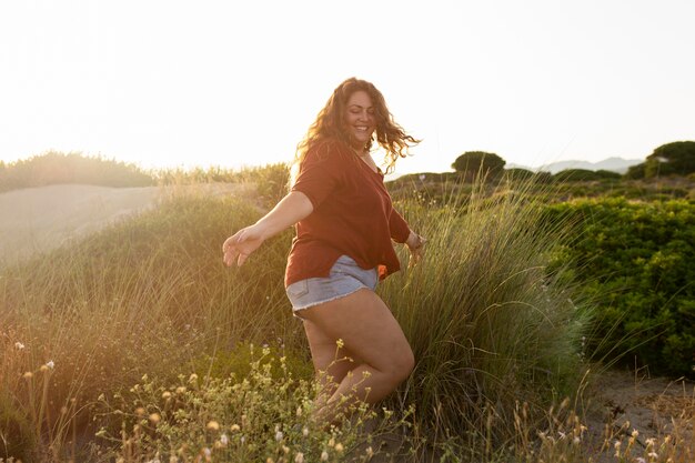 Zijaanzicht van gelukkige vrouw in de natuur