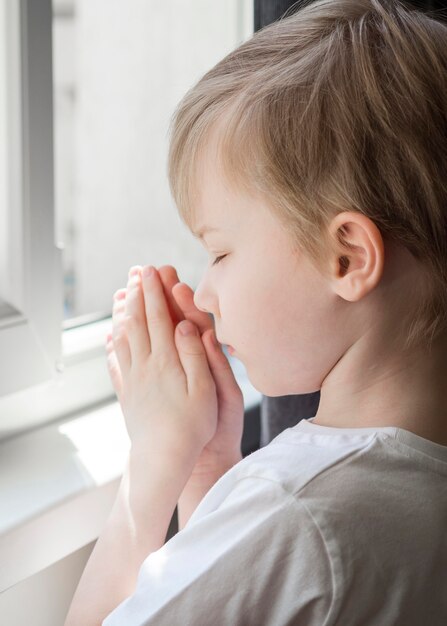 Zijaanzicht van het kleine jongen bidden