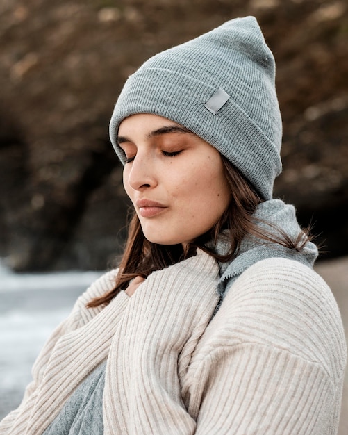 Gratis foto zijaanzicht van het mooie vrouw stellen op het strand