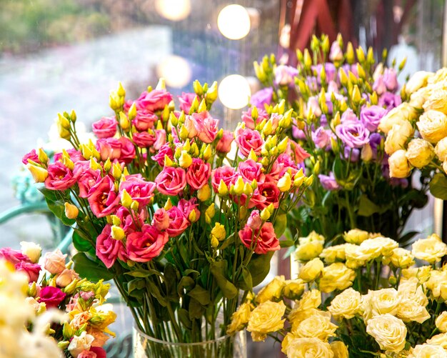 Zijaanzicht van het roze boeket van kleurennevelrozen in glasvaas