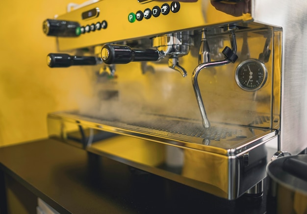 Zijaanzicht van het schoonmaken van de koffiemachine met stoom