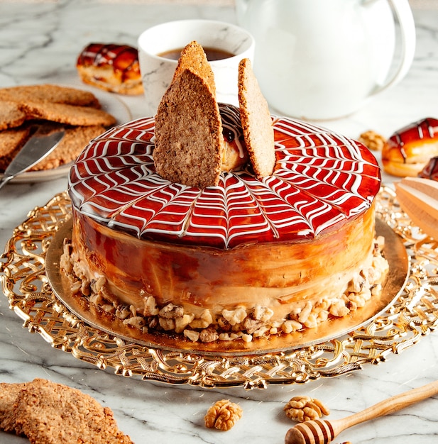 Gratis foto zijaanzicht van karamel cake met koekjes op zilveren dienblad