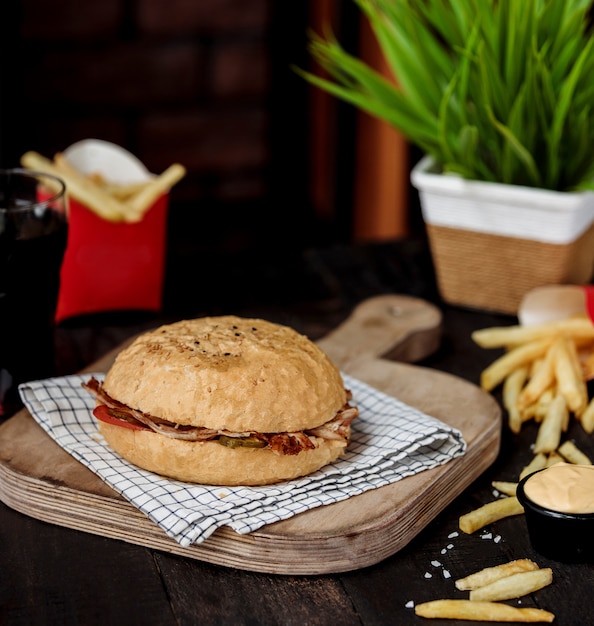 Zijaanzicht van kebab doner met rundvlees en groenten in brood op houten snijplank