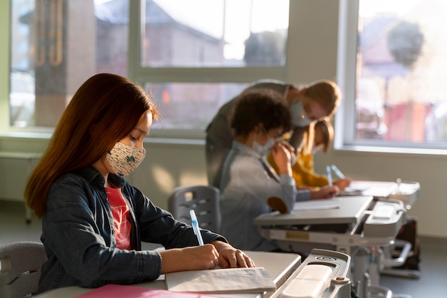 Zijaanzicht van kinderen die op school leren tijdens de pandemie