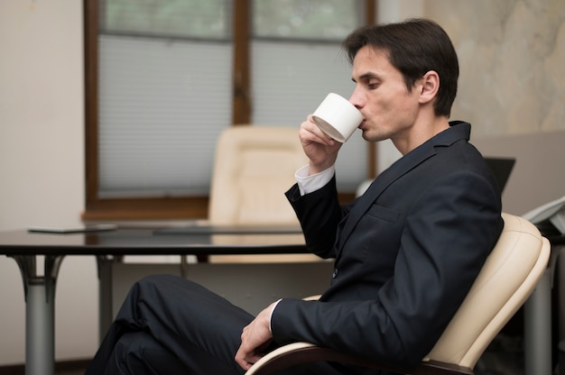 Zijaanzicht van man koffie drinken