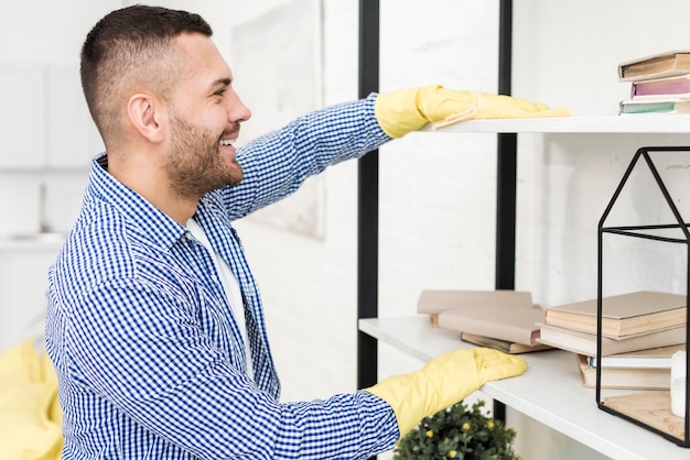 Gratis foto zijaanzicht van man schoonmaken met vod