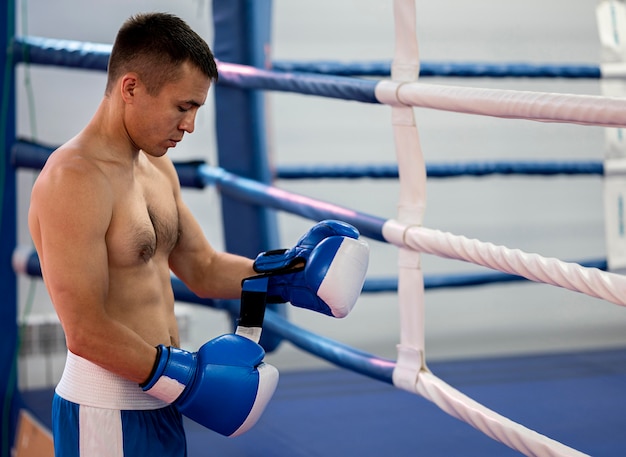 Gratis foto zijaanzicht van mannelijke bokser naast ring