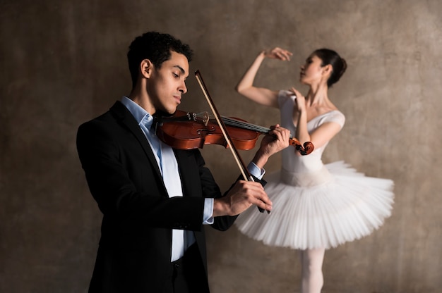 Gratis foto zijaanzicht van mannelijke muzikant en ballerina