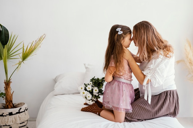 Zijaanzicht van moeder en dochter met boeket van Lentebloemen