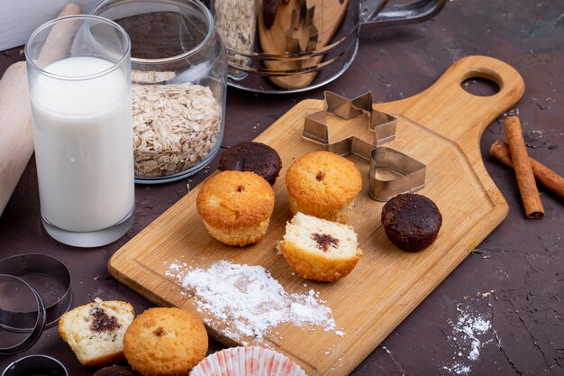 Zijaanzicht van muffins met chocolade op een houten snijplank