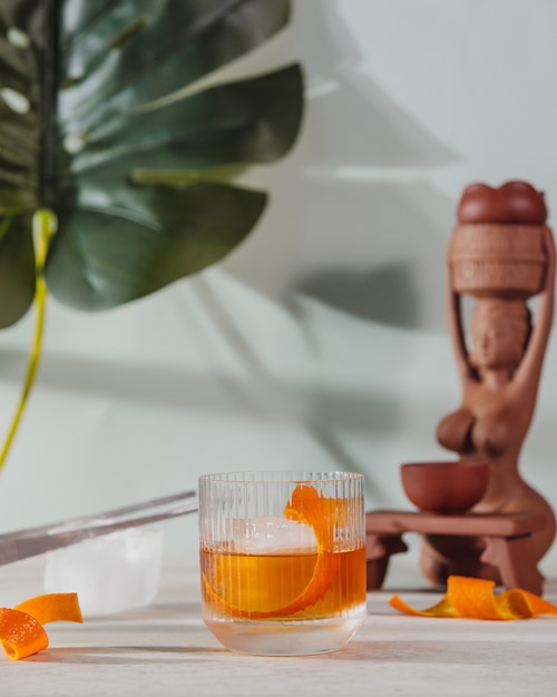 Zijaanzicht van negroni cocktailglas met sinaasappelschil op tafel