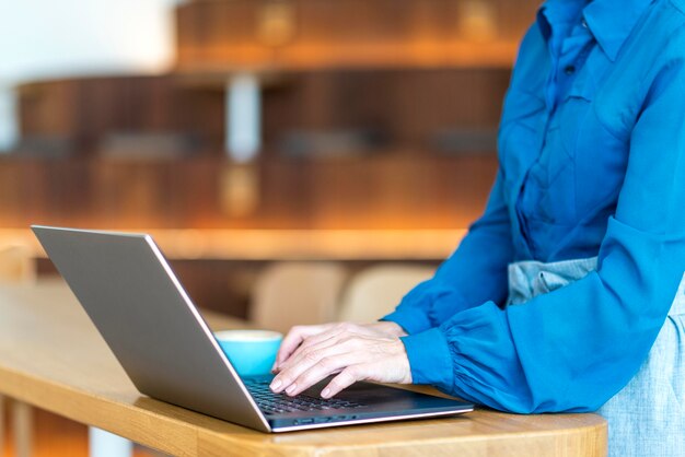Zijaanzicht van oudere bedrijfsvrouw die aan laptop werkt