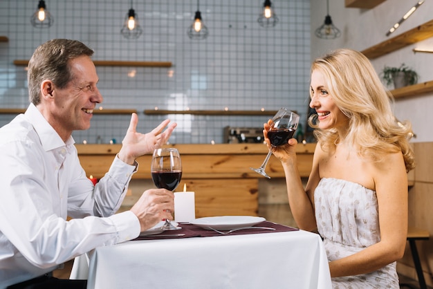 Gratis foto zijaanzicht van paar tijdens een romantisch diner