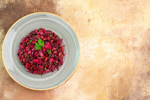 Zijaanzicht van plaat van een rode salade met greens erop op een houten backgorund