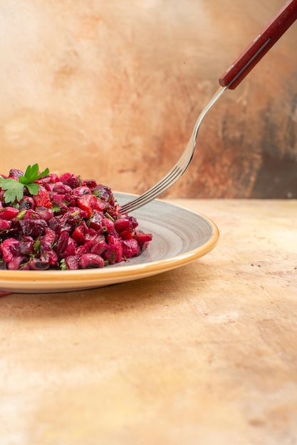 Gratis foto zijaanzicht van plaat van een rode salade met greens erop op een houten backgorund