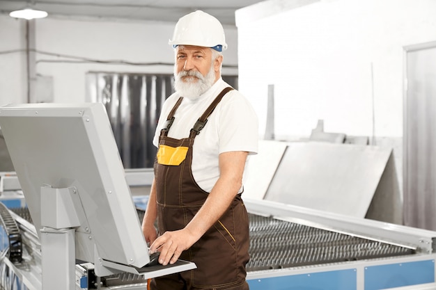 Zijaanzicht van professionele werknemer van metalen fabriek