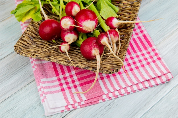 Zijaanzicht van radijzen in mandplaat op plaiddoek en houten achtergrond