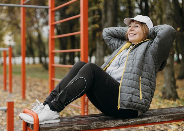 Zijaanzicht van smiley senior vrouw buitenshuis uit te werken