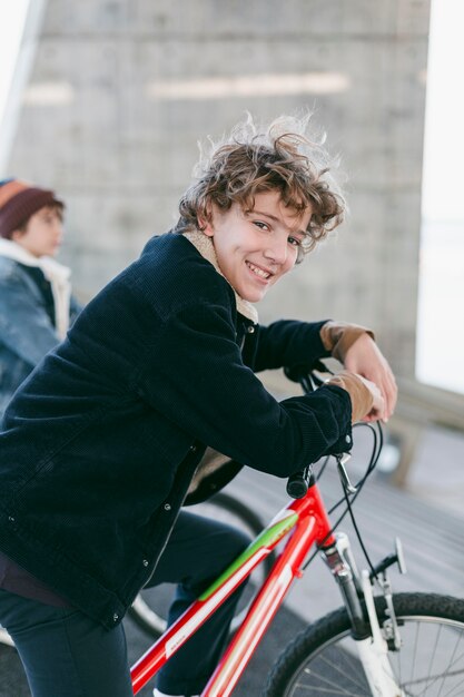 Zijaanzicht van smileyjongens buiten in de stad met hun fietsen