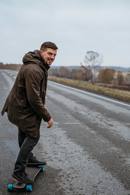 Zijaanzicht van smileymens met skateboard op de weg