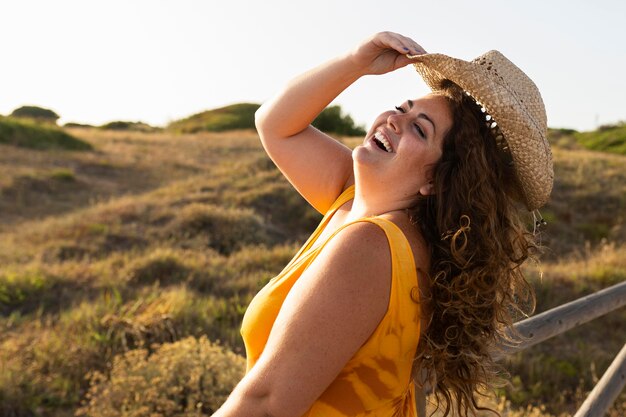 Zijaanzicht van smileyvrouw die in openlucht stellen