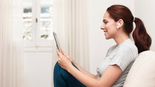 Zijaanzicht van smileyvrouw die tablet bekijken